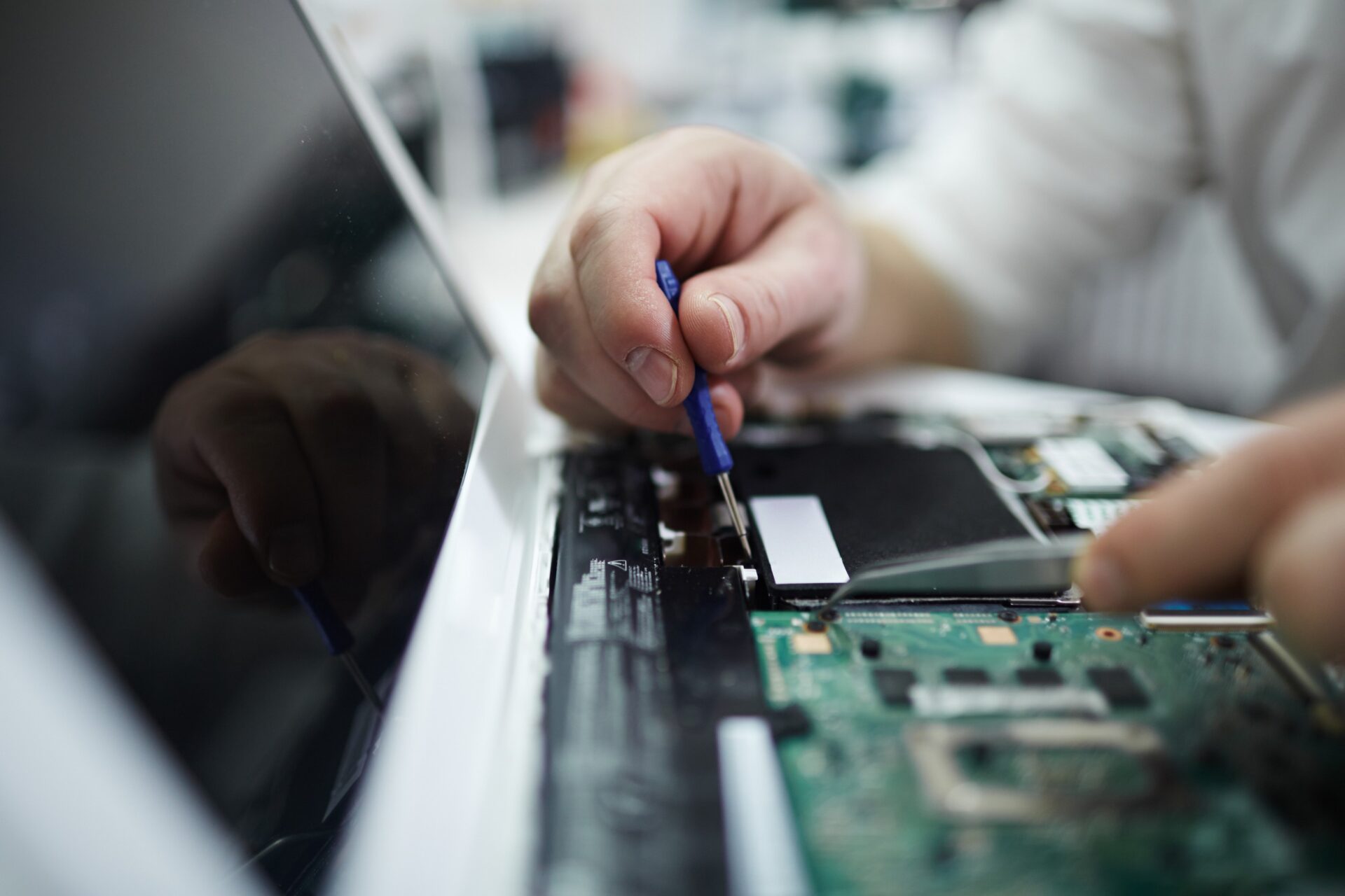 Man Fixing Components in Disassembled Laptop
